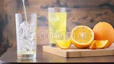 在装有冰块的玻璃杯中<strong>倒</strong>入橙汁<strong>汽水</strong>。 木制背景，带有橙色水果